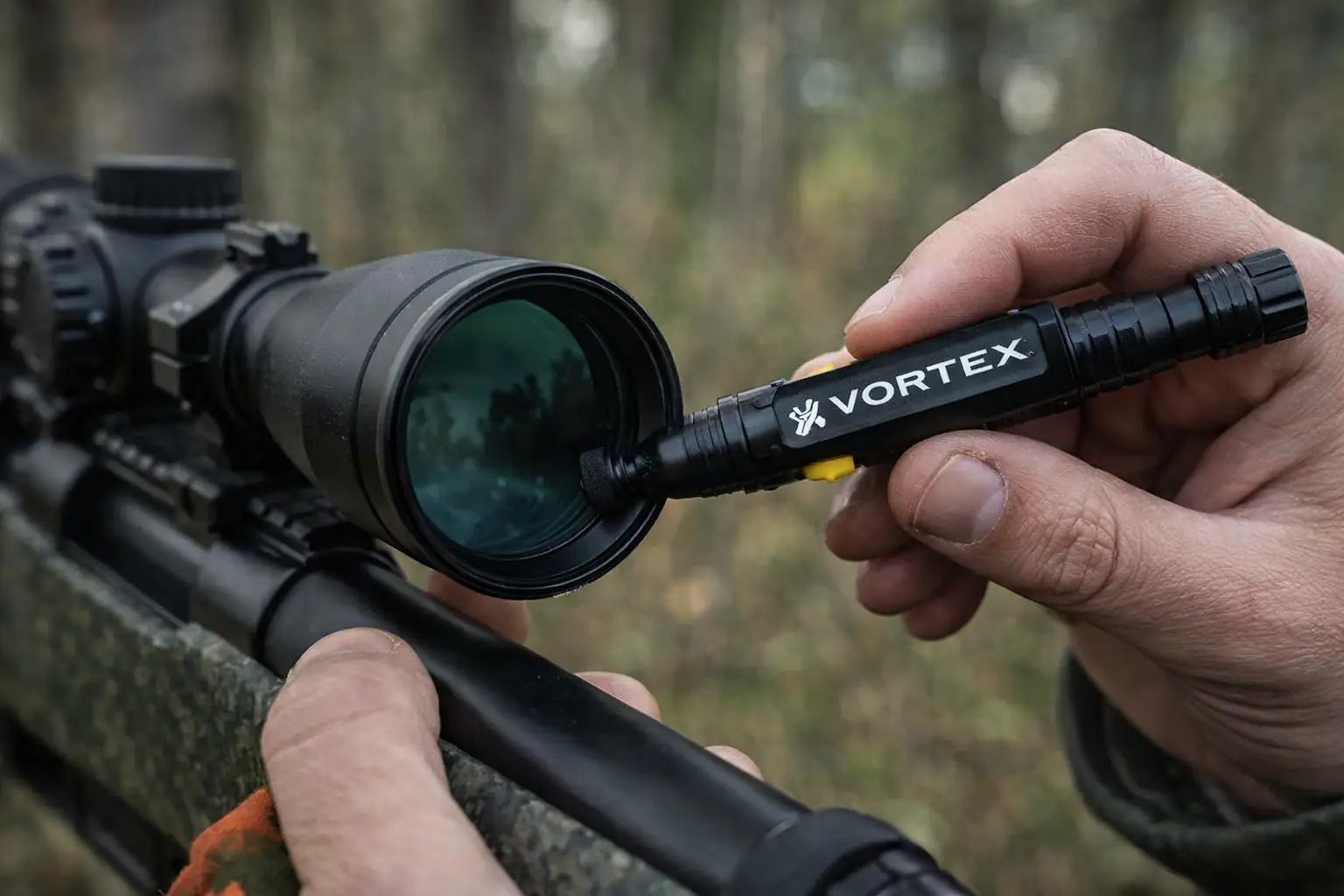 Jägare rengör kikarsikte med Vortex linsrengöringspenna under jakt i skogen